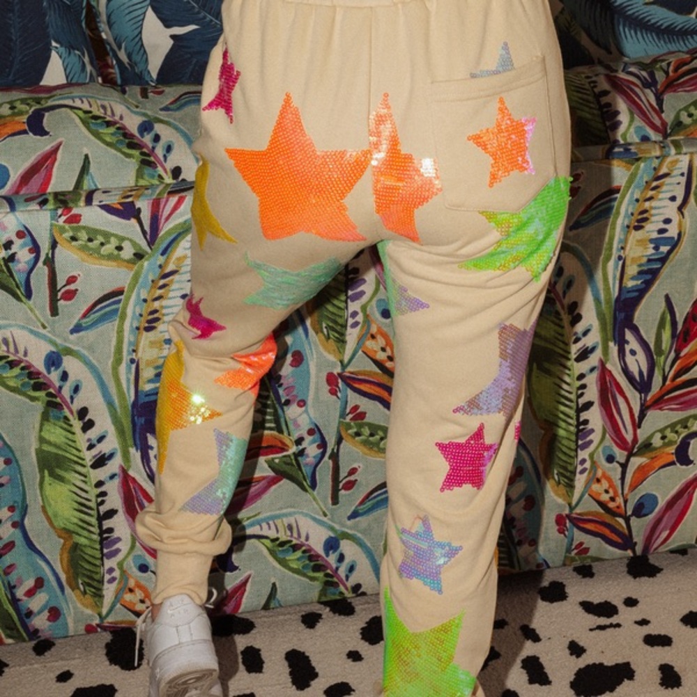 QUEEN OF SPARKLES Cream and Orange Track Pants with Colorful Star Design